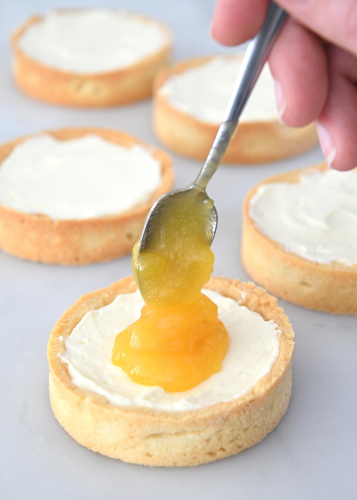 Filling the blueberry lemon tartlets with mascarpone and lemon curd
