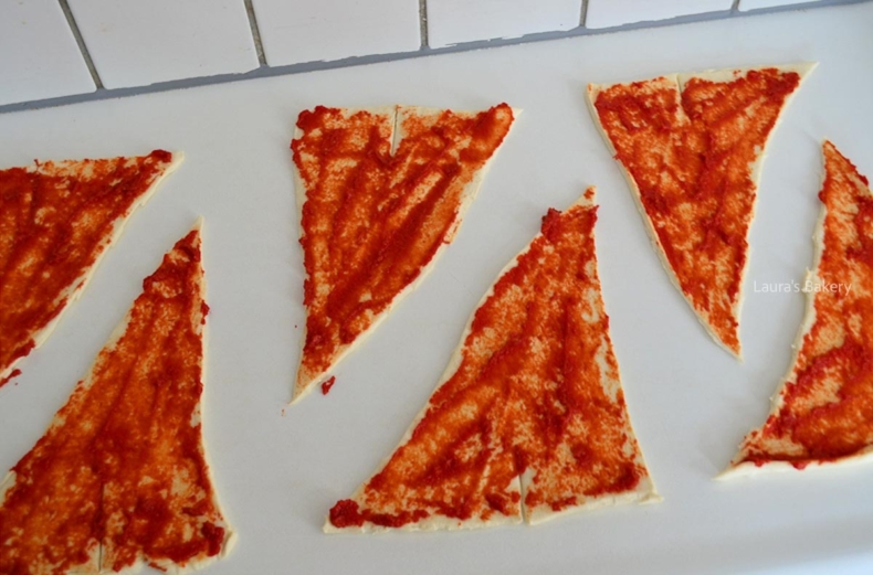 Tomato paste spread on each pizza dough triangle