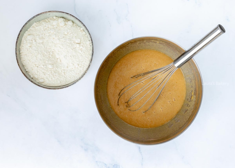 Melted butter and sugar mixture in a bowl with flour in another bowl for making blondies.