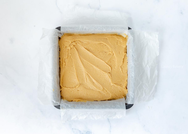 Blondie batter in a parchment-lined baking dish.