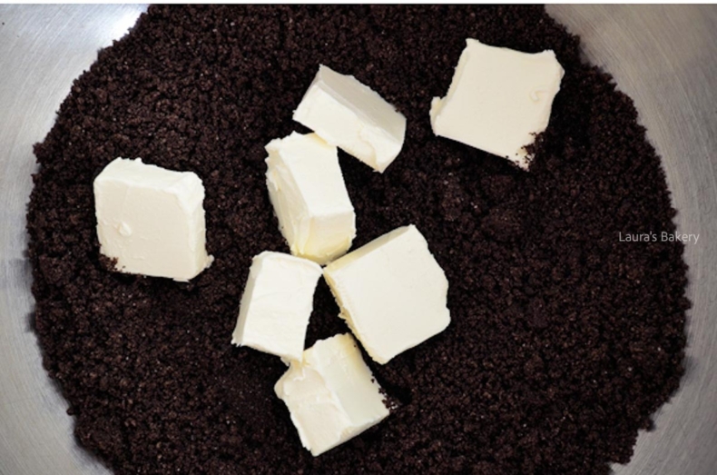 Oreo cookie crumbs with cream cheese in a mixing bowl to make Oreo balls